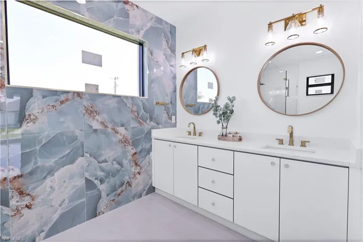 Bathroom with vanity, tile patterned floors, and tile walls