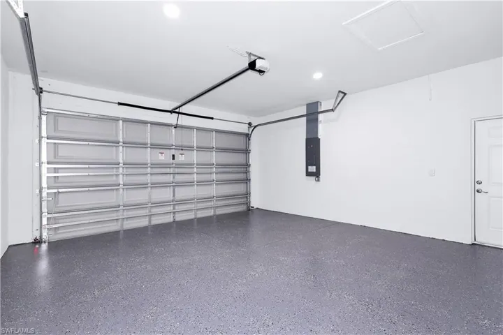 Garage with electric panel and a garage door opener