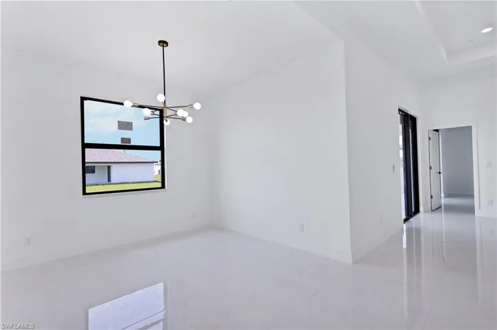 Spare room featuring a chandelier and light tile patterned flooring