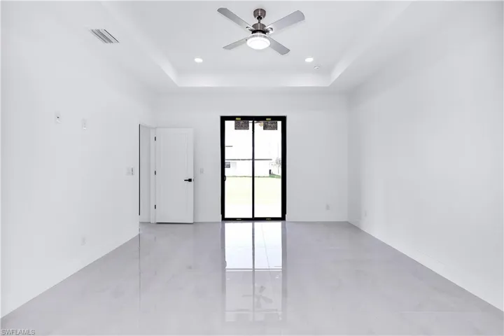 Empty room with a tray ceiling and ceiling fan