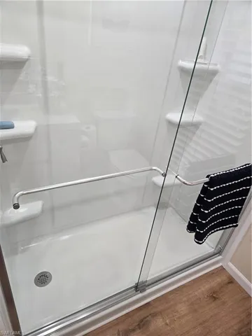 Bathroom featuring wood-type flooring and walk in shower