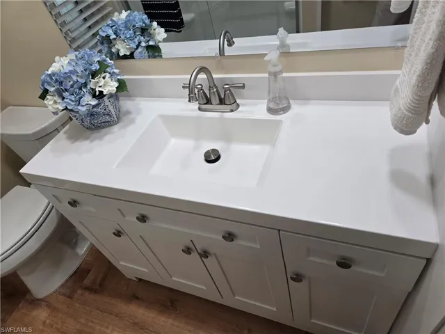 Bathroom featuring hardwood / wood-style floors, vanity, and toilet