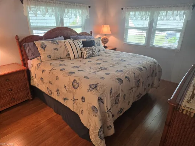 Bedroom featuring dark hardwood / wood-style floors and multiple windows