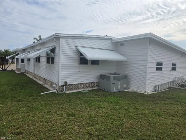 View of property exterior featuring a yard and central air condition unit