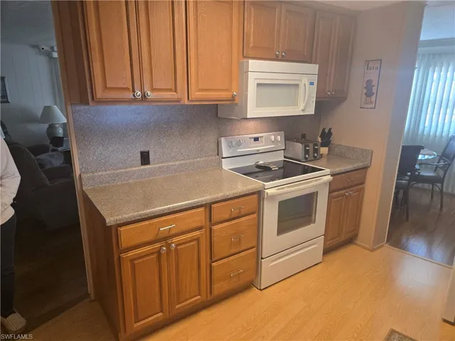 Kitchen featuring light wood-type flooring and white appliances