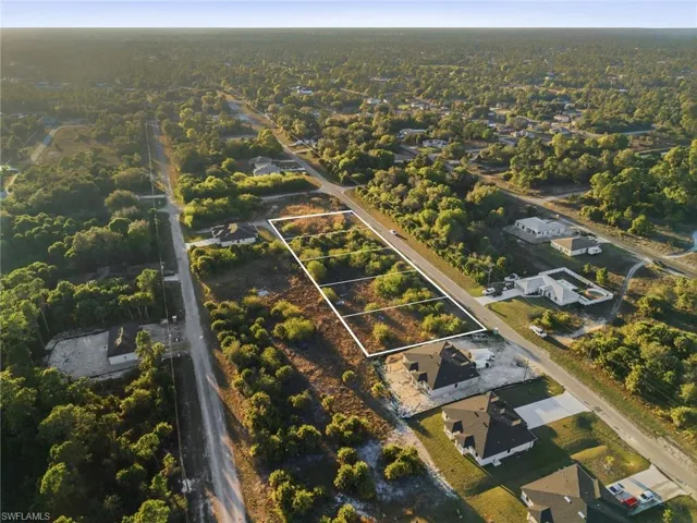 Aerial view of property and surrounding area with property parcel outlined and nearby suburban area