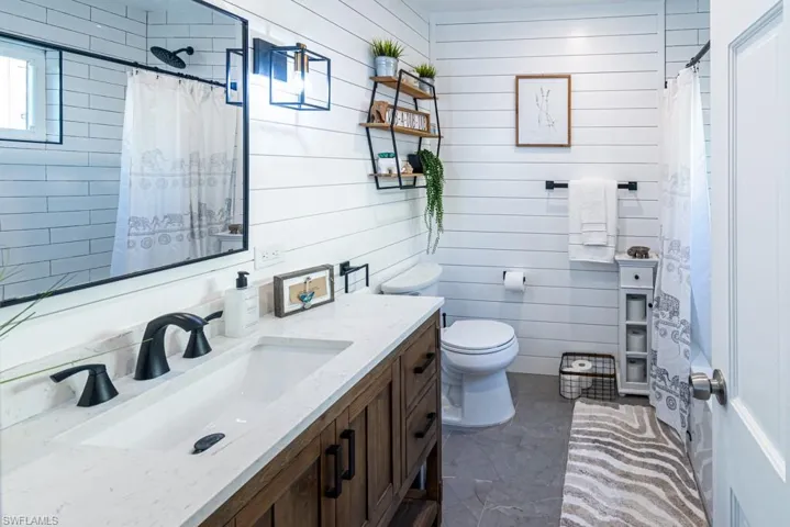 Bathroom with a shower with shower curtain, toilet, and vanity