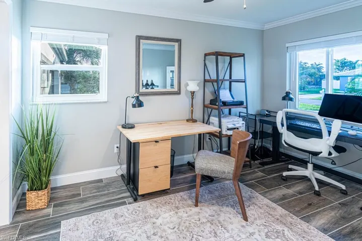Office area featuring wood finish floors, ornamental molding, and baseboards