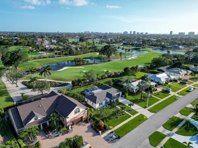 Birds eye view of property featuring golf course view and a water view