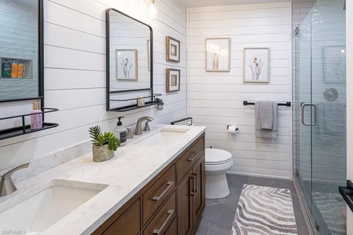 Bathroom with a sink, a stall shower, and toilet