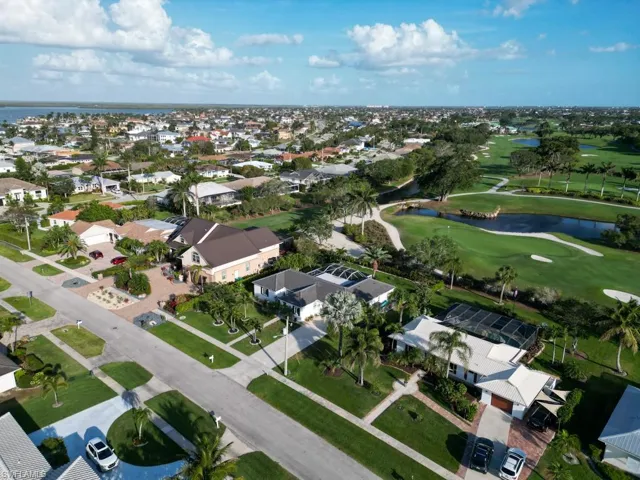 Aerial view featuring a water view, view of golf course, and a residential view