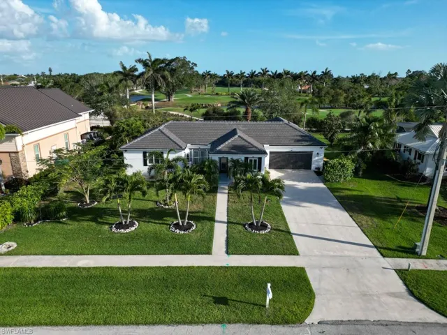 Ranch-style house featuring driveway, an attached garage, and a front lawn