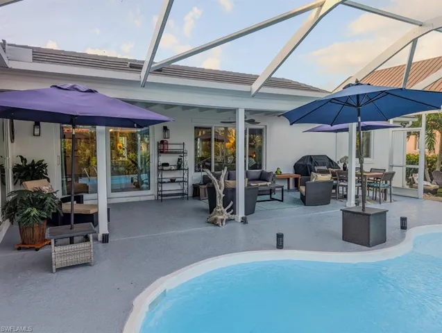 Pool with a patio, glass enclosure, grilling area, a ceiling fan, and outdoor lounge area