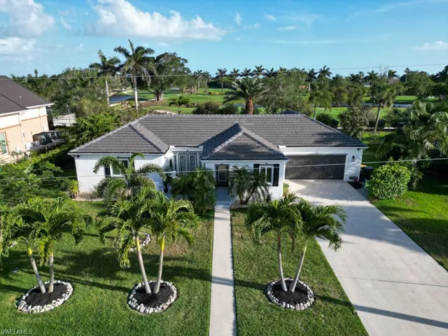 Ranch-style home with a tile roof, concrete driveway, stucco siding, a front yard, and a garage