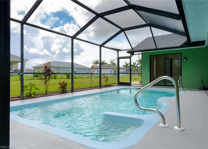 View of pool featuring screened enclosure, a yard, and a patio.