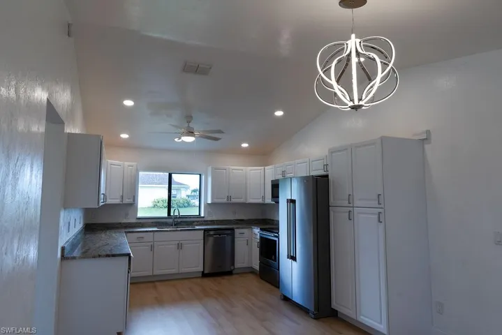 Kitchen with white cabinets, appliances with stainless steel finishes.