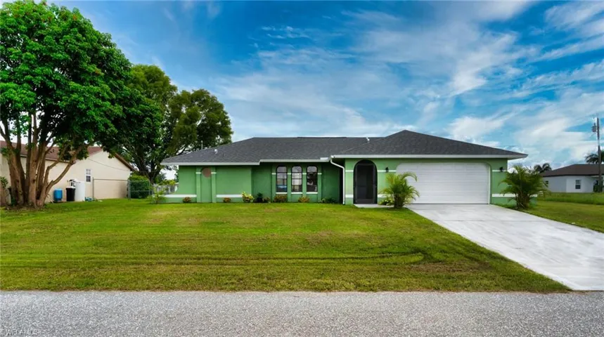 Ranch-style house with two cars garage and a front lawn.