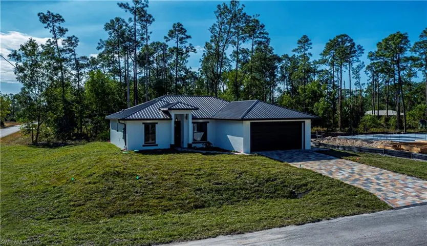 View of front of property with a garage and a front yard