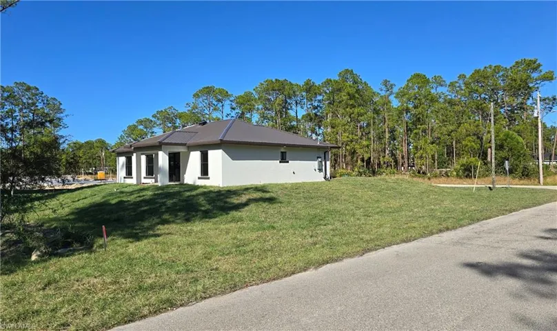 View of side of property featuring a yard