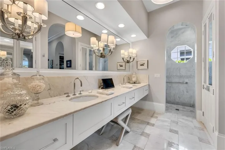 Marble counters, floors with mosaic inserts, and mirrored His & Hers storage closets.