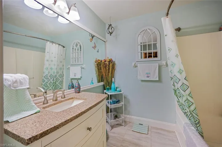 Bathroom with vanity, tile patterned floors, and shower / tub combo