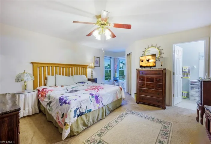 Bedroom with light colored carpet and ceiling fan