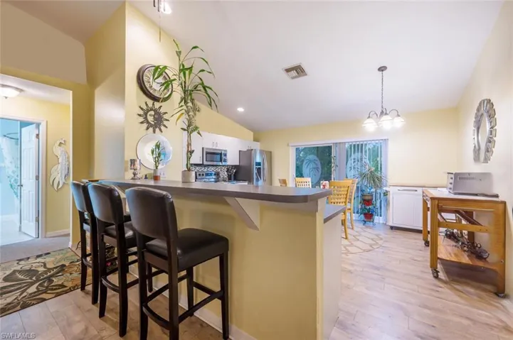 Kitchen featuring white cabinets. Kitchen breakfast bar, kitchen peninsula, and appliances with stainless steel finishes
