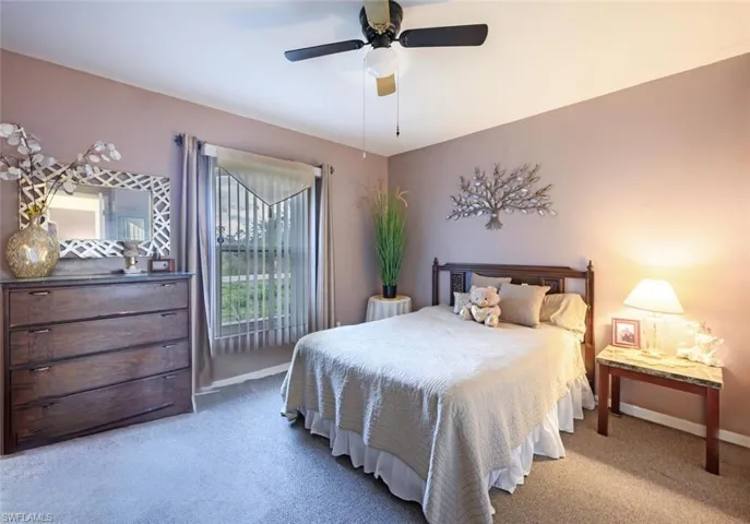 Carpeted bedroom featuring ceiling fan