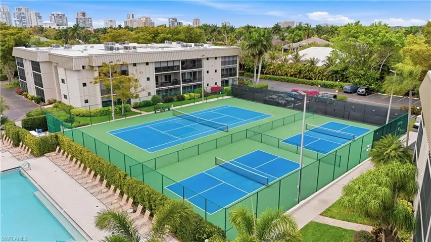 View of tennis court with a city view and a community pool