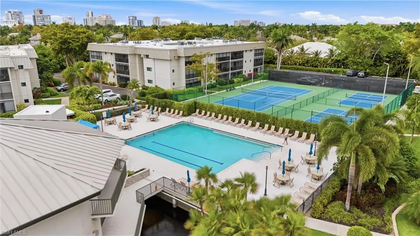 Community pool featuring a patio area, view of wooded area, and a city view