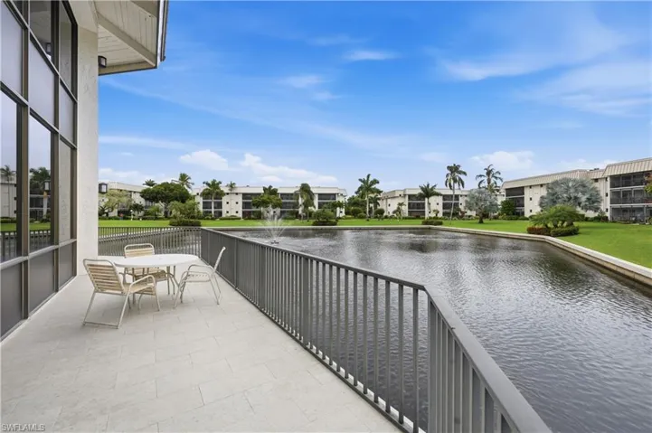 Balcony featuring a water view and outdoor dining space