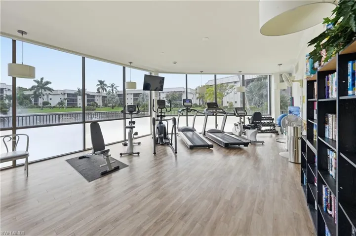 Exercise room with floor to ceiling windows and a residential view