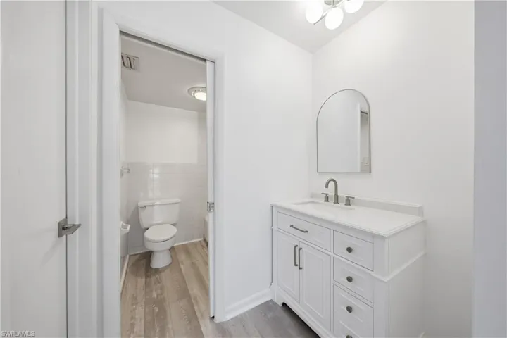 Bathroom with vanity, light wood-type flooring, and tile walls