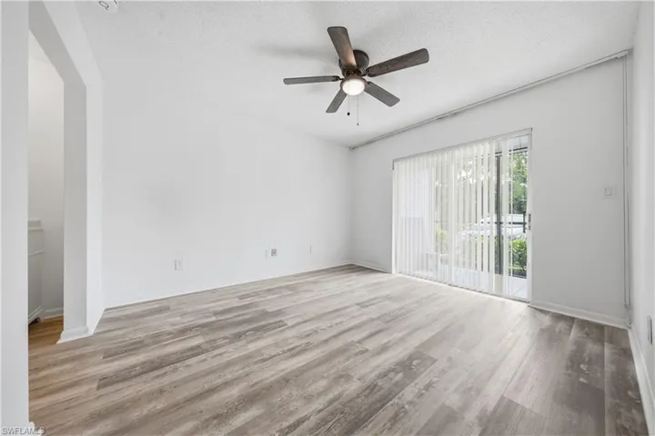 Unfurnished room with a textured ceiling, light wood-style flooring, and ceiling fan