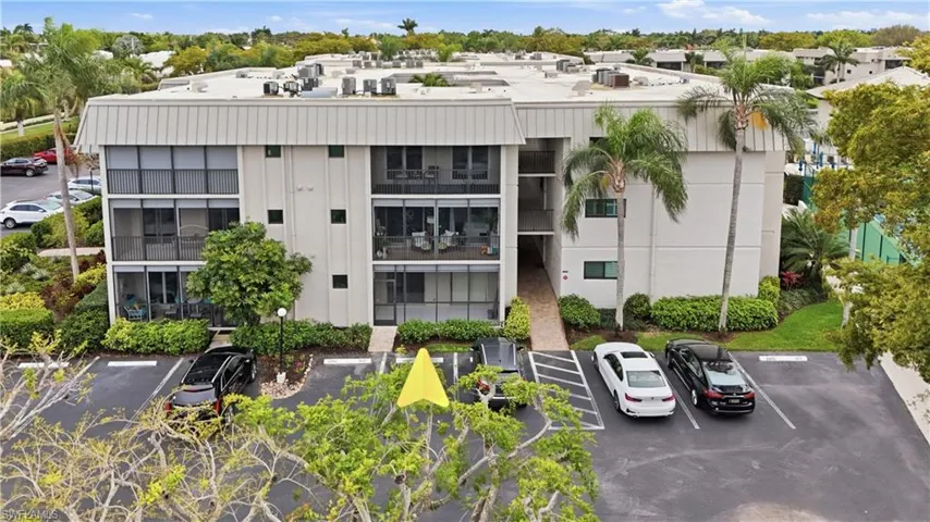 View of apartment building / complex with uncovered parking