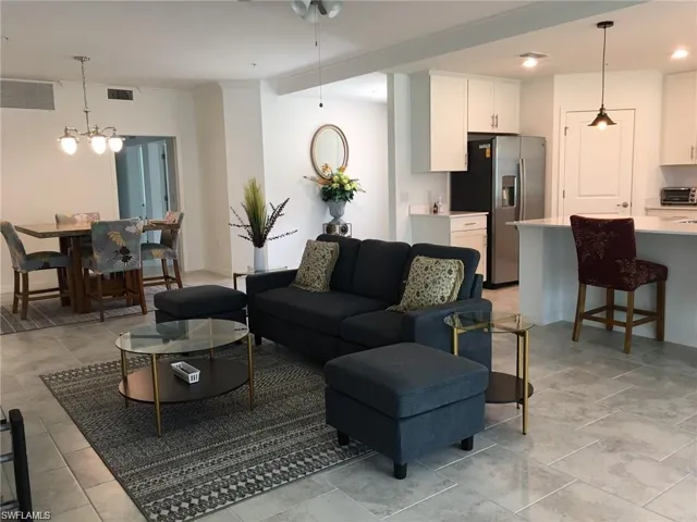 Living room with light tile patterned floors and a chandelier