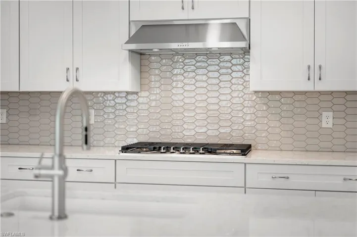 Kitchen layout with gas cooktop and stainless steel farmhouse sink