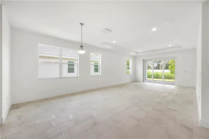 Casual dining and great room living space with sliding glass doors leading out to covered lanai