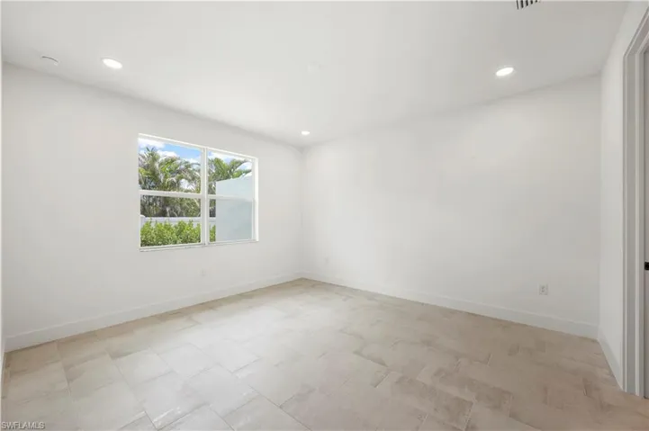 Primary bedroom suite with view of landscaped yard
