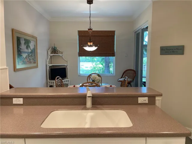 Kitchen featuring decorative light fixtures, sink, and ornamental molding