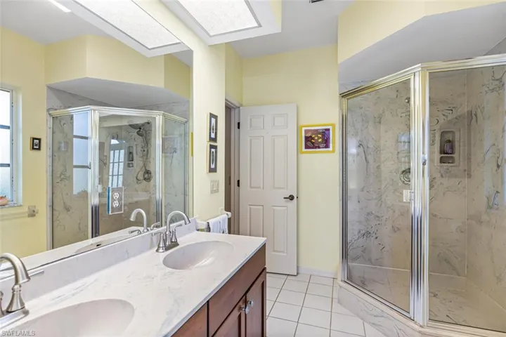 Guest Bath with double vanity, walk-in shower, door to pool.