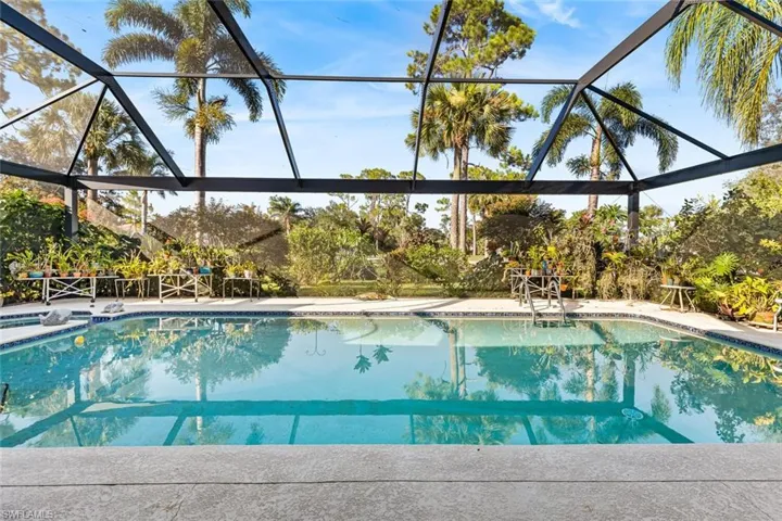 Pool view to private golf course through picture window screening.