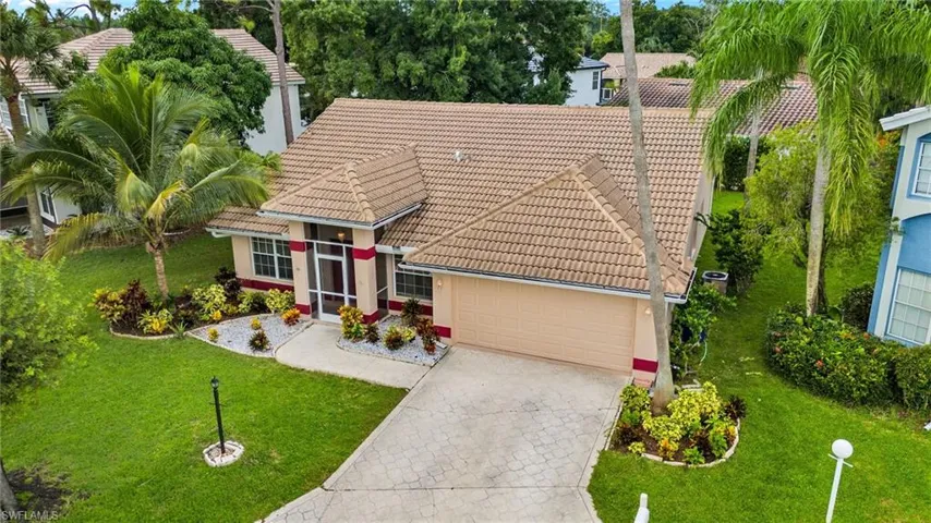 View of front of home with a tiled roof, stucco siding, decorative driveway, an attached garage, and a front yard