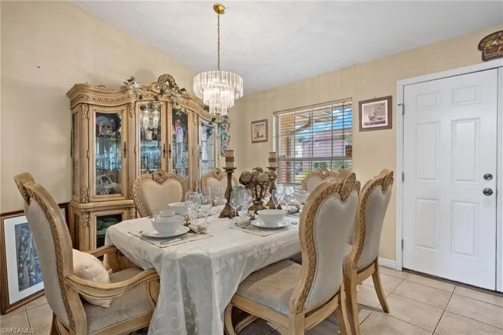 Dining area with light tile patterned floors and a chandelier