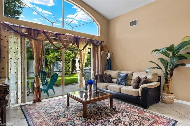 Living room with light tile patterned floors and a towering ceiling
