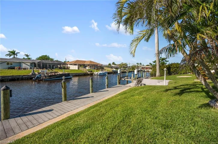 Dock with a water view, a lawn, a residential view, and boat lift