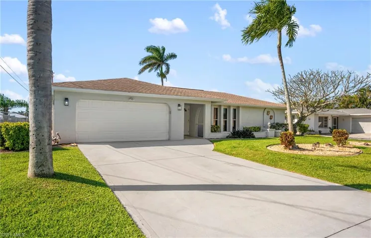 Single story home with stucco siding, concrete driveway, an attached garage, and a front lawn