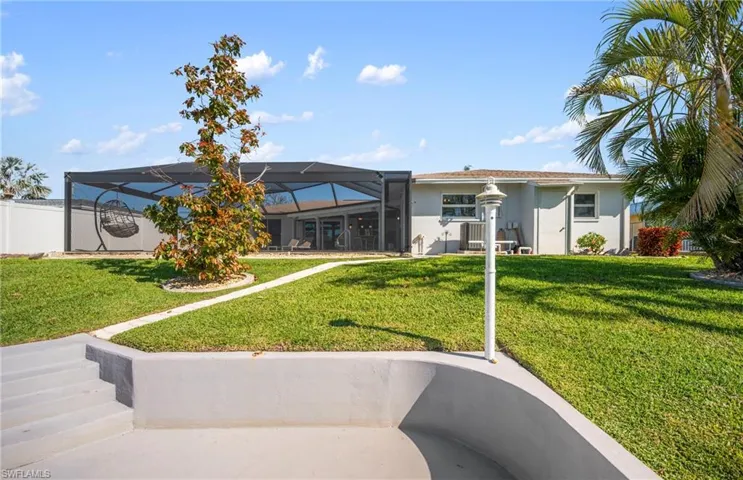 Back of house featuring a lanai, stucco siding, a sunroom, and a patio