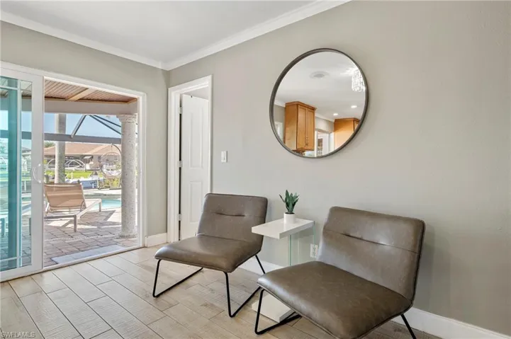 Sitting room with a sunroom, wood tiled floors, and crown molding