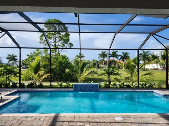 View of swimming pool featuring pool water feature and glass enclosure